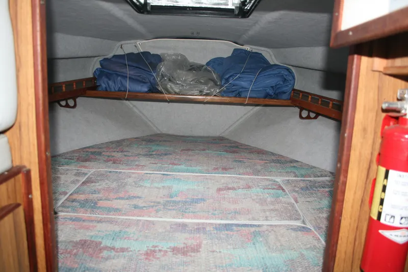 Slide: The Image of Interior cabin of a 1991 Olympic 23' Runabout boat with bedding and fire extinguisher. - 14