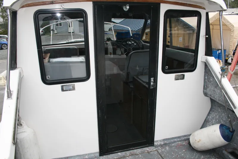 Slide: The Image of 1991 Olympic 23' Runabout boat interior view with black-framed windows and door. - 2