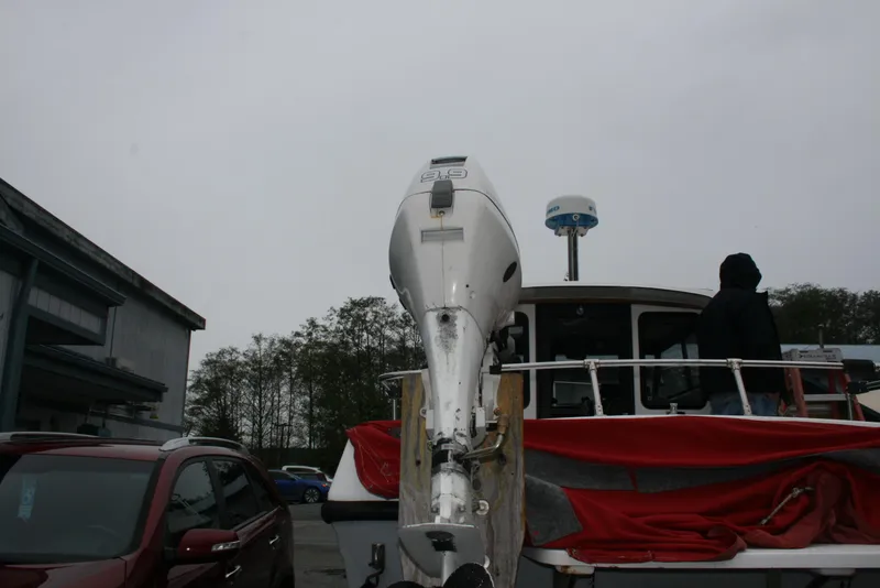 Slide: The Image of 1991 Olympic 23' Runabout boat with outboard motor in a parking lot. - 20