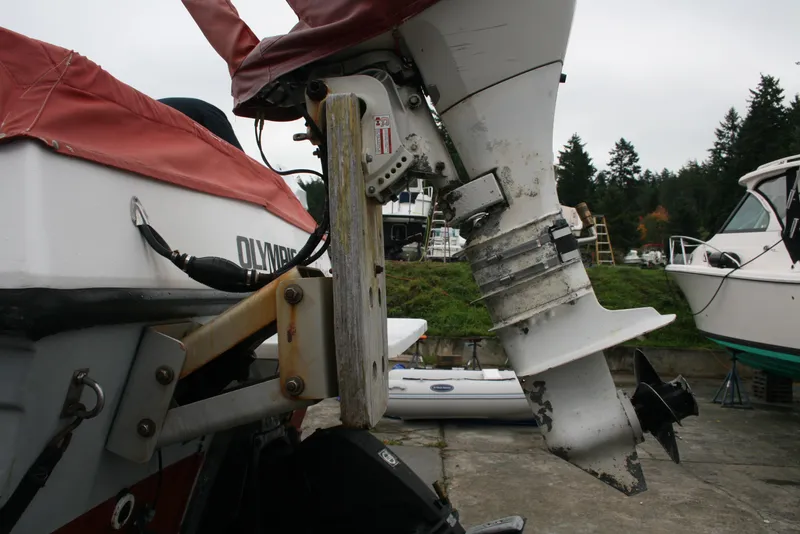 Slide: The Image of 1991 Olympic 23' Runabout boat with outboard motor in a marina. - 22