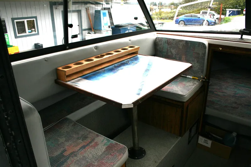 Slide: The Image of Interior of a 1991 Olympic 23' Runabout boat with seating and table. - 9