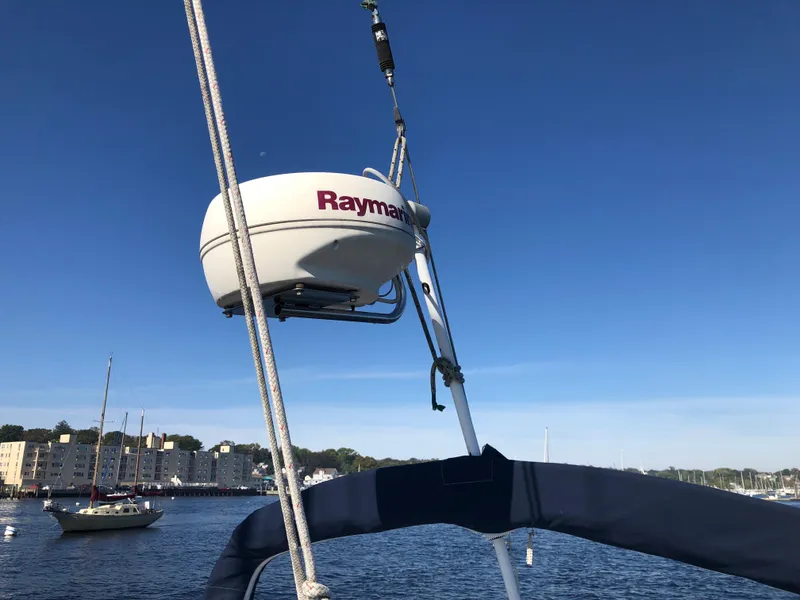 Slide: The Image of Radar equipment on a 1985 Beneteau First 345 sailboat, with a scenic harbor view. - 42