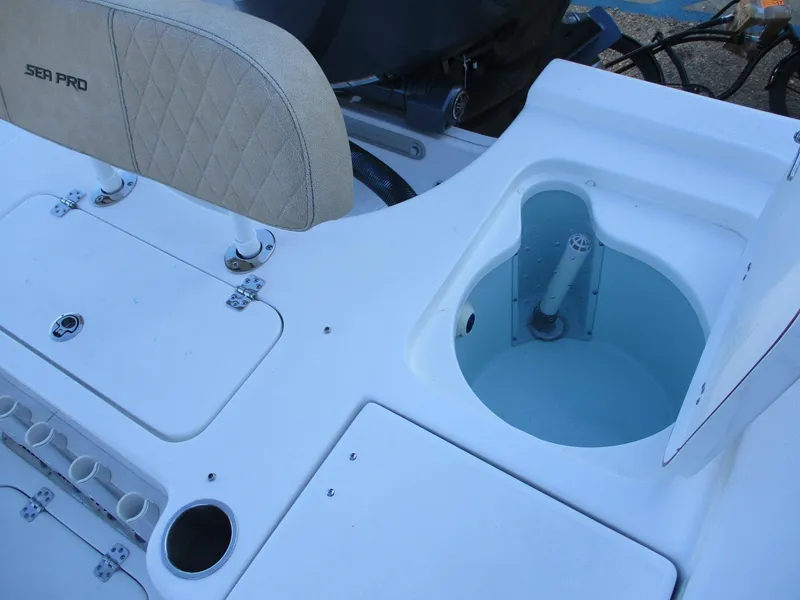 Slide: The Image of 2024 Sea Pro 228 DLX Bay boat interior with livewell and storage compartments. - 10