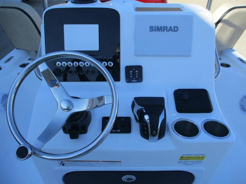Slide: The Image of 2024 Sea Pro 228 DLX Bay boat helm with Simrad electronics and stainless steel steering wheel. - 13