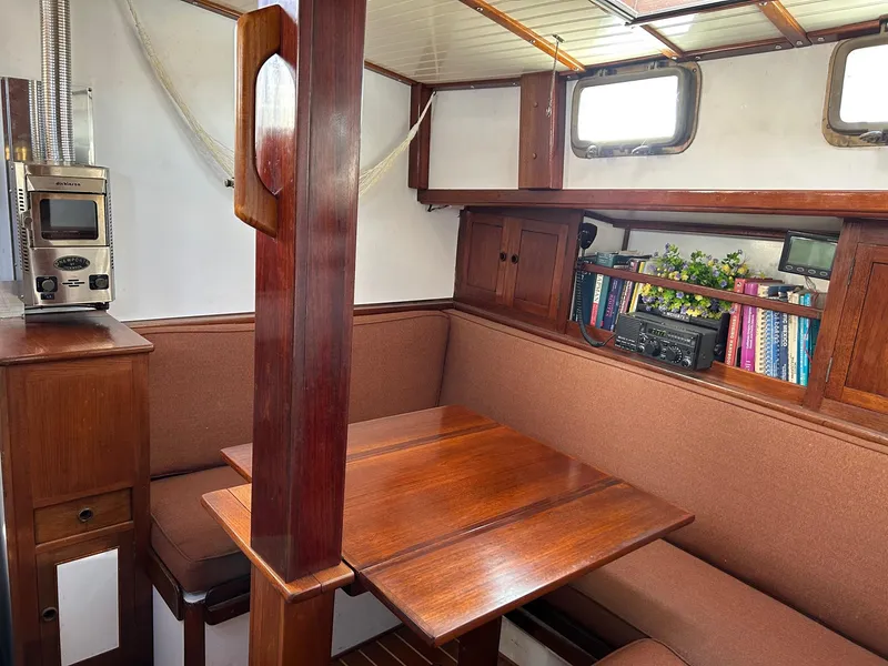 Slide: The Image of Cozy interior of 1975 Salar 40 sailboat with wooden dining area and bookshelf. - 10