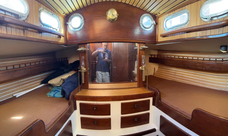 Slide: The Image of Interior of a 1975 Salar 40 sailboat cabin with wooden furnishings and portholes. - 15
