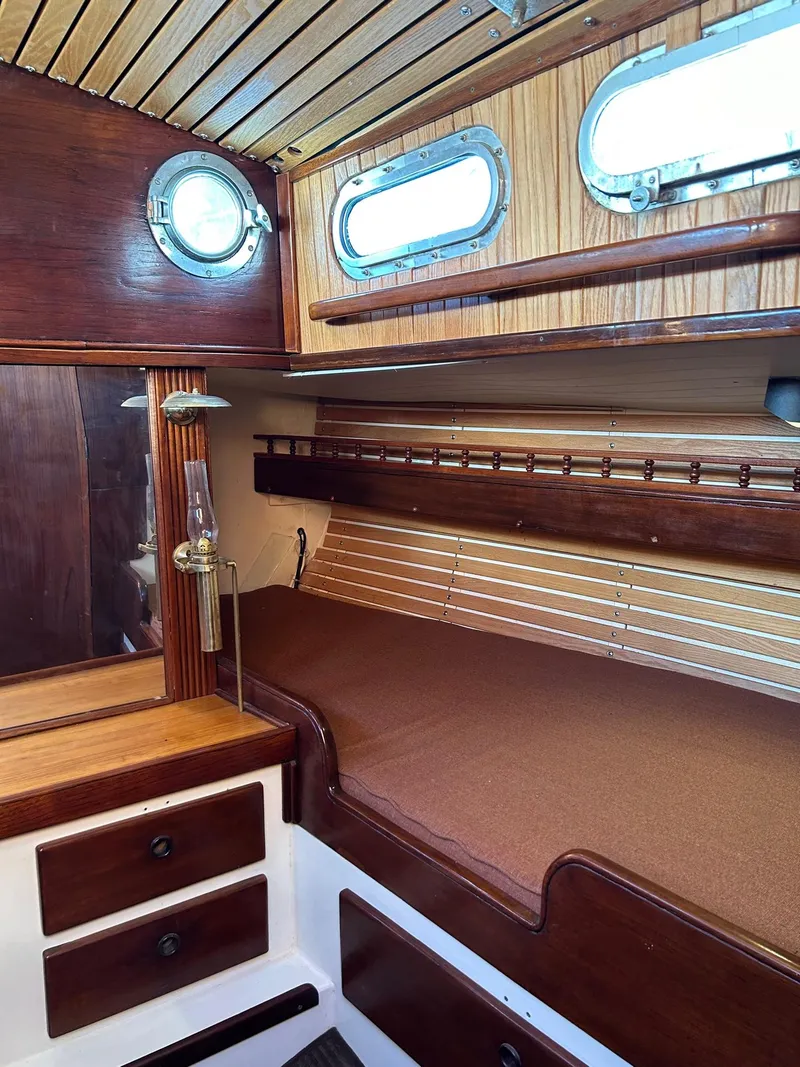 Slide: The Image of Interior of a 1975 Salar 40 sailboat with wooden paneling and cozy berth. - 18