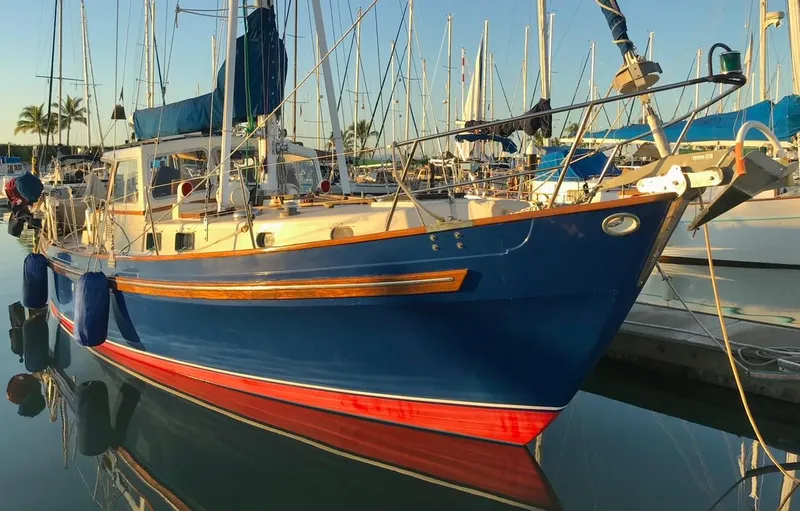 Slide: The Image of 1975 Salar 40 sailboat docked in marina, blue hull with red stripe, sunny day. - 24
