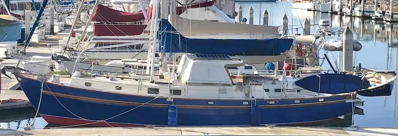 Slide: The Image of Salar 40 sailboat from 1975 docked at a marina, featuring a classic blue hull. - 32