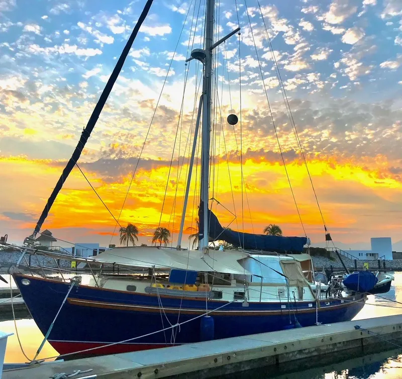 Slide: The Image of Salar 40 sailboat from 1975 docked at sunset with vibrant sky. - 34
