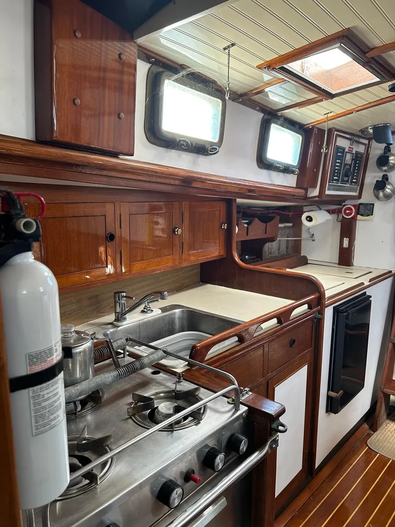 Slide: The Image of 1975 Salar 40 yacht kitchen with wooden cabinets, stove, and sink. - 4
