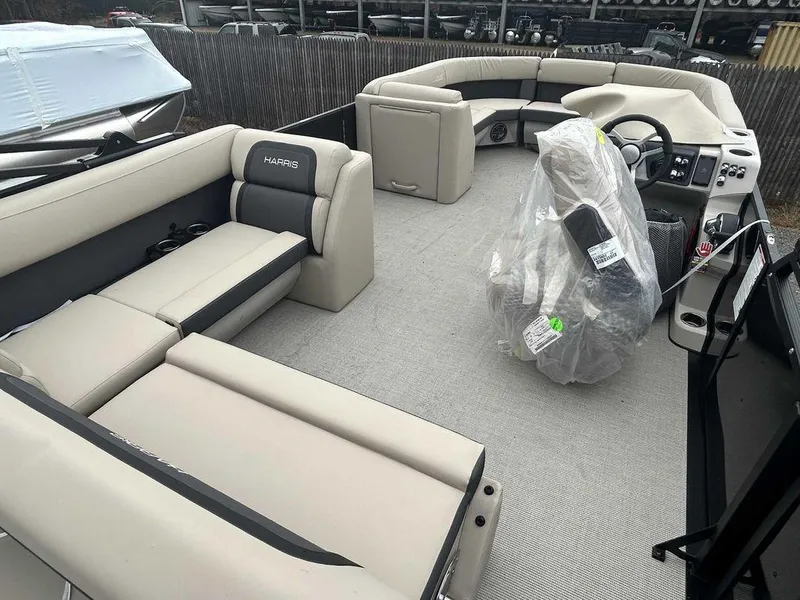 Slide: The Image of 2024 Harris Cruiser 230 boat interior with beige seating and covered captain's chair. - 6