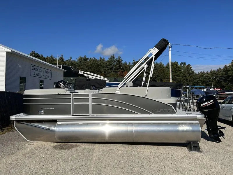 Slide: The Image of 2024 Harris Cruiser 190 pontoon boat with Mercury outboard motor, docked on a sunny day. - 1