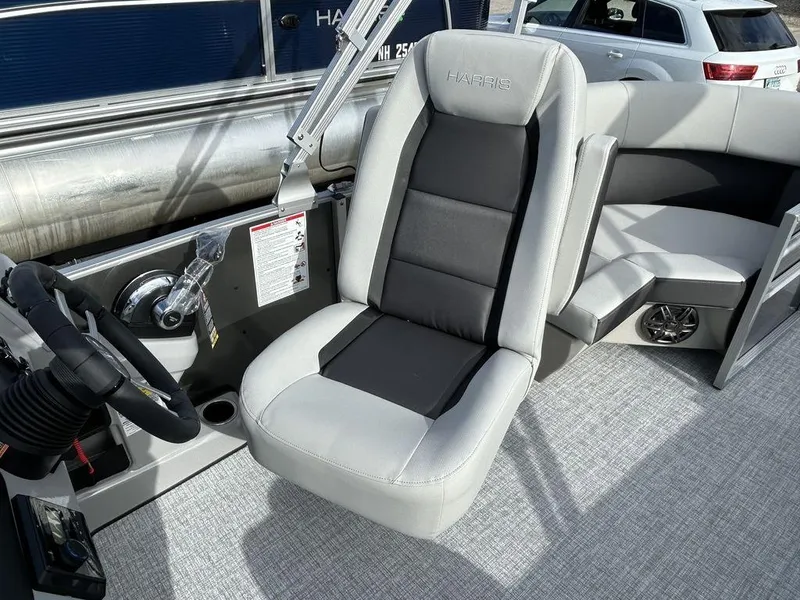 Slide: The Image of 2024 Harris Cruiser 190 boat interior with captain's chair and steering console. - 11