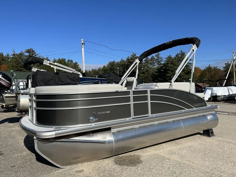 Slide: The Image of 2024 Harris Cruiser 190 pontoon boat in a parking lot. - 2