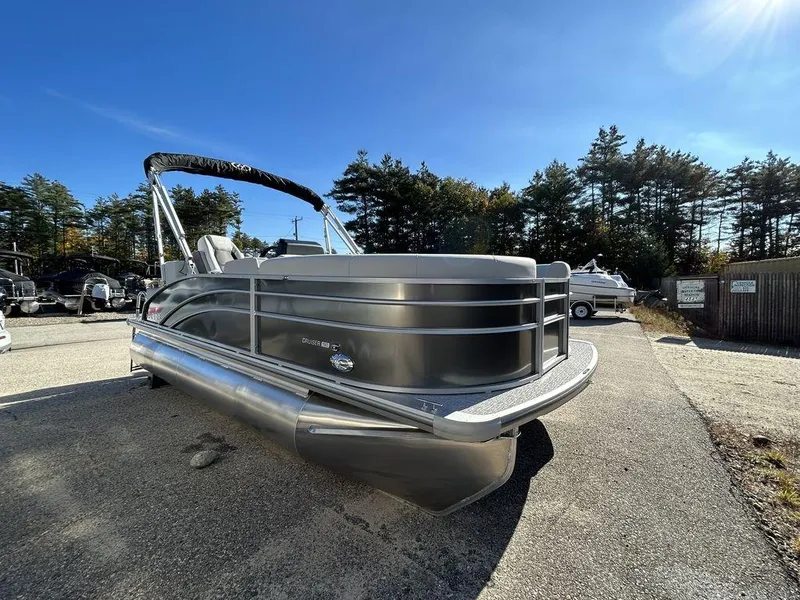 Slide: The Image of 2024 Harris Cruiser 190 pontoon boat in a parking lot under a clear blue sky. - 5