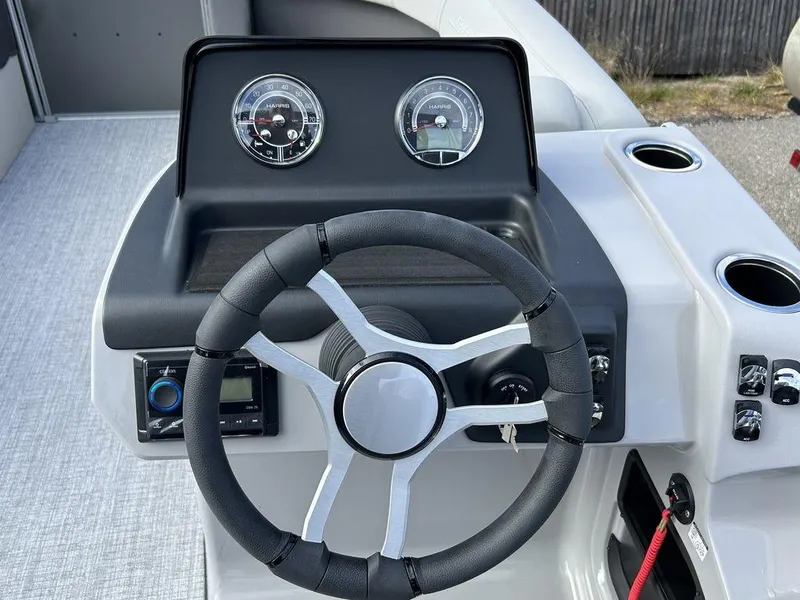 Slide: The Image of 2024 Harris Cruiser 190 boat dashboard with steering wheel and gauges. - 9