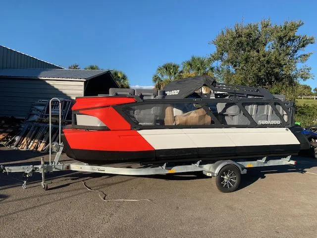 The Image of 2024 Sea-Doo Cruise 21 on trailer, red and white, parked outdoors. - 1