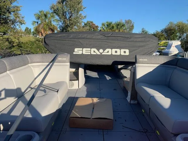 Slide: The Image of 2024 Sea-Doo Cruise 21 boat interior with covered engine, spacious seating, and sunny outdoor setting. - 4