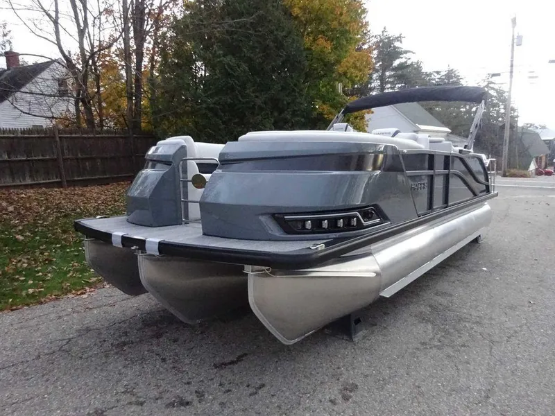 Slide: The Image of 2024 Harris Grand Mariner 230 pontoon boat on a road, surrounded by trees. - 3