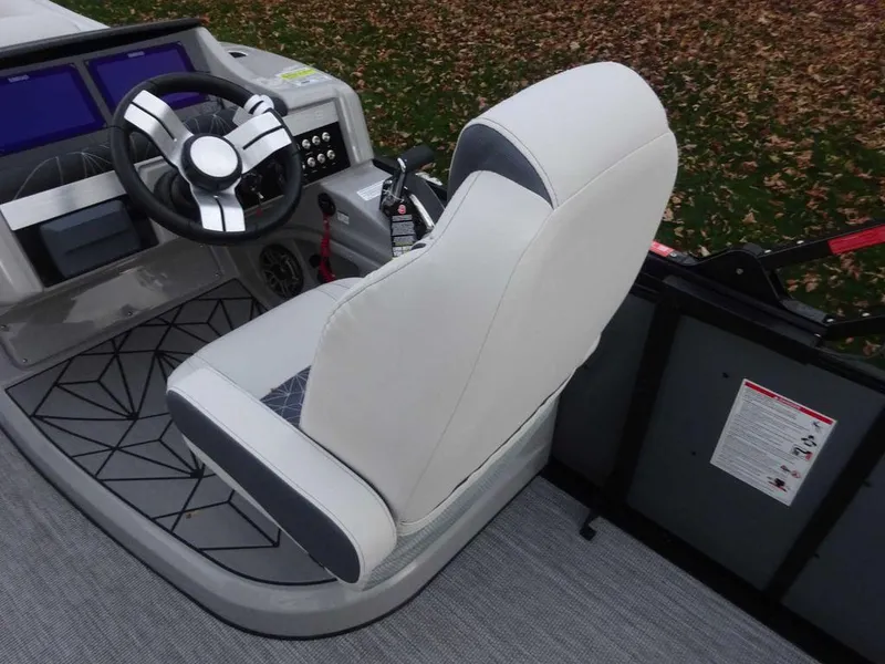 Slide: The Image of 2024 Harris Grand Mariner 230 boat helm with modern steering wheel and captain's chair. - 4