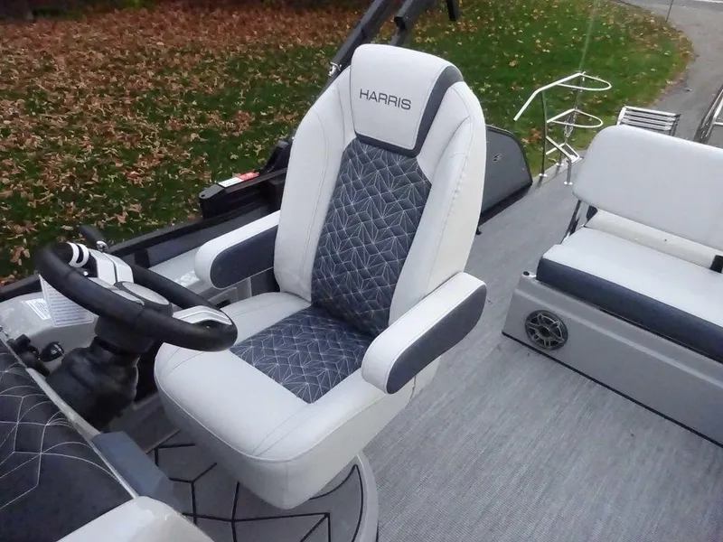 Slide: The Image of 2024 Harris Grand Mariner 230 boat interior with plush seating and steering wheel. - 5