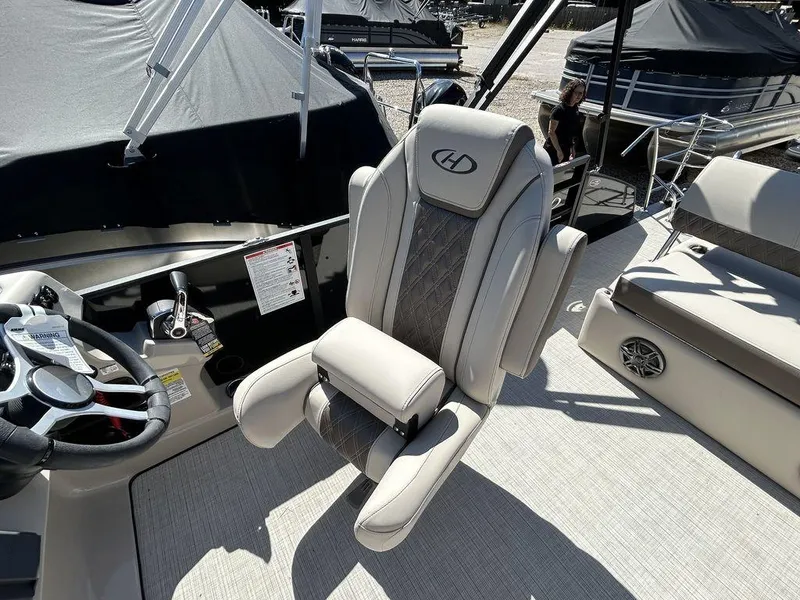Slide: The Image of 2024 Harris Sunliner 230 boat interior with luxury captain's chair and steering console. - 12