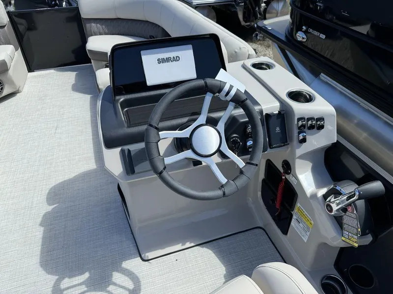 Slide: The Image of 2024 Harris Sunliner 230 boat dashboard with steering wheel and Simrad display. - 6