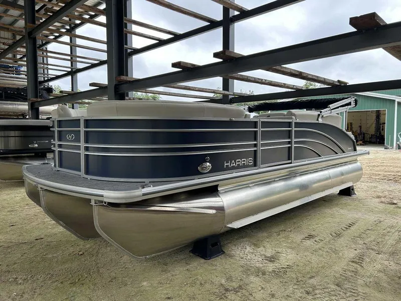 Slide: The Image of 2024 Harris Sunliner 210 pontoon boat in storage, featuring sleek design and metallic finish. - 4