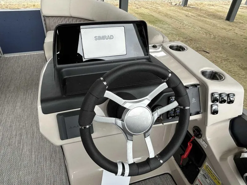 Slide: The Image of 2024 Harris Sunliner 210 boat dashboard with steering wheel and Simrad display. - 7