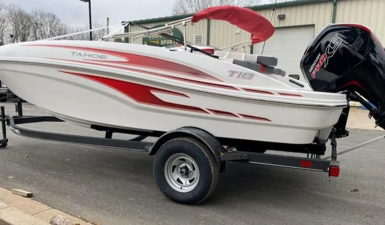 Slide: The Image of 2024 Tahoe T18 boat with red accents on a trailer. - 2