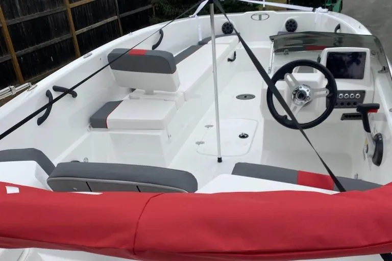 Slide: The Image of 2024 Tahoe T18 boat interior with red and gray seating, steering wheel, and control panel. - 3