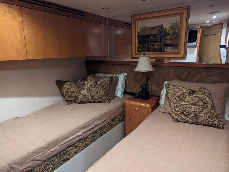 Slide: The Image of 2007 Hatteras 68 Convertible yacht bedroom with twin beds and elegant decor. - 10