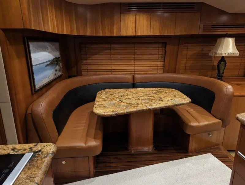 Slide: The Image of Luxurious dining area in a 2007 Hatteras 68 Convertible yacht with granite table and leather seating. - 8