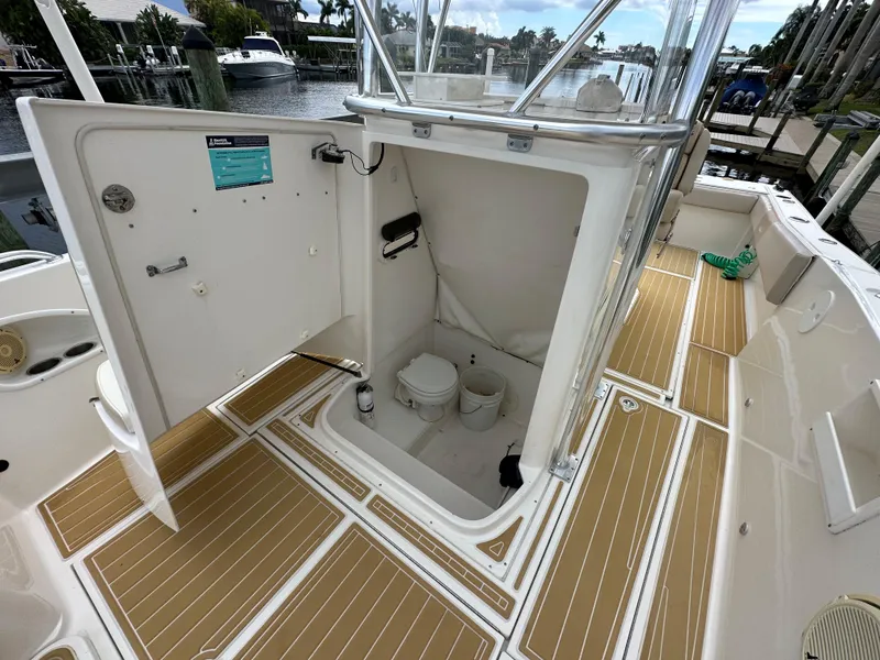Slide: The Image of 2014 Stamas 317 Tarpon boat with open hatch showing interior storage and toilet. - 8