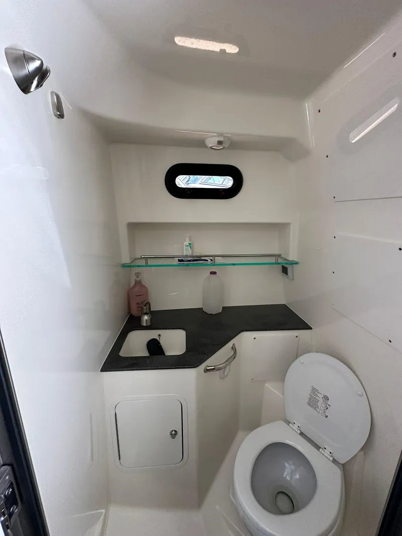Slide: The Image of 2023 Boston Whaler 325 Conquest boat bathroom with sink, toilet, and shelf. - 14
