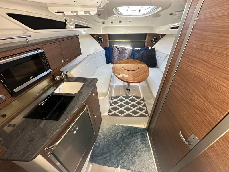 Slide: The Image of Interior of 2023 Boston Whaler 325 Conquest with kitchenette and seating area. - 3