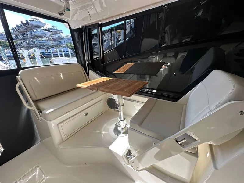 Slide: The Image of Interior of 2023 Boston Whaler 325 Conquest with seating and wooden table. - 4