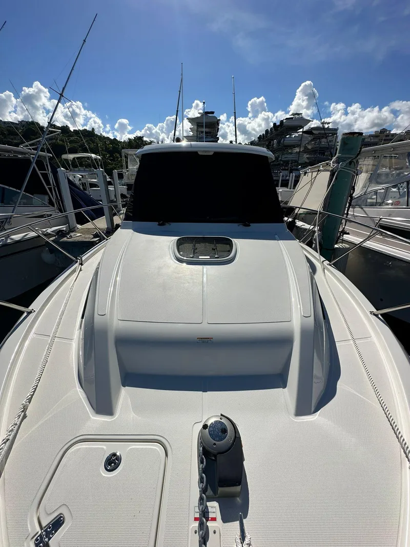Slide: The Image of 2023 Boston Whaler 325 Conquest docked under a clear blue sky. - 8