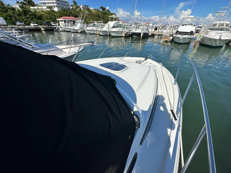 Slide: The Image of 2023 Boston Whaler 325 Conquest docked at a marina under a clear blue sky. - 9