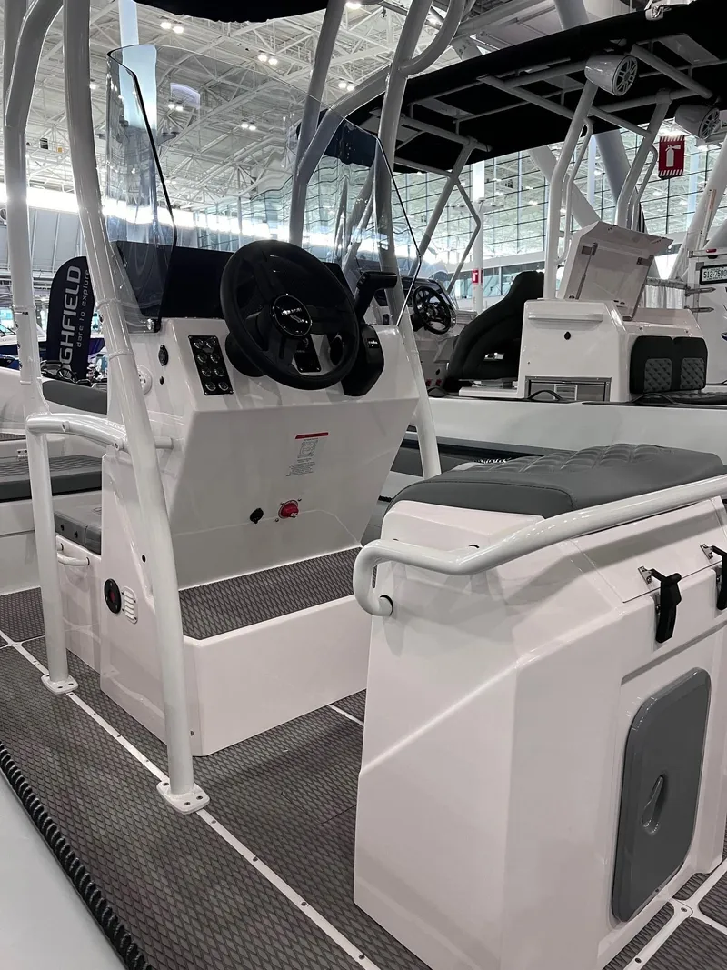 Slide: The Image of 2024 Highfield Patrol 600 boat interior with steering console and seating. - 2