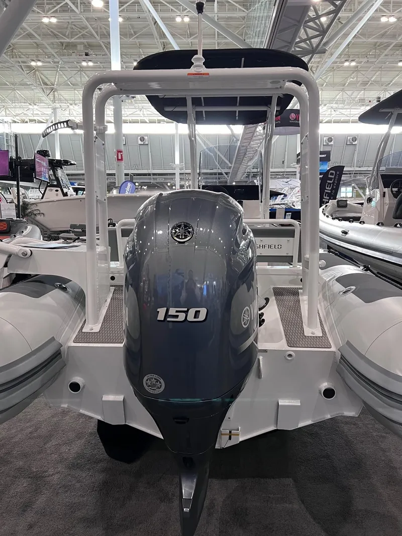 Slide: The Image of 2024 Highfield Patrol 600 with 150 HP outboard motor at a boat show. - 5