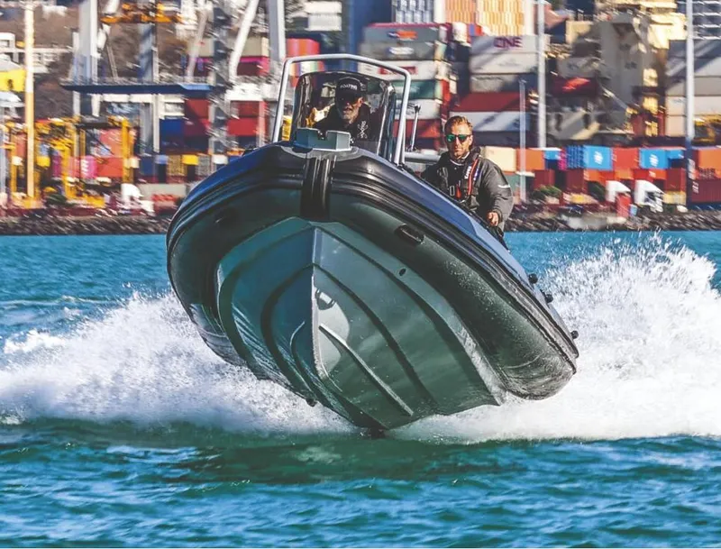 Slide: The Image of 2024 Highfield Patrol 600 boat speeding on water near a busy port. - 7