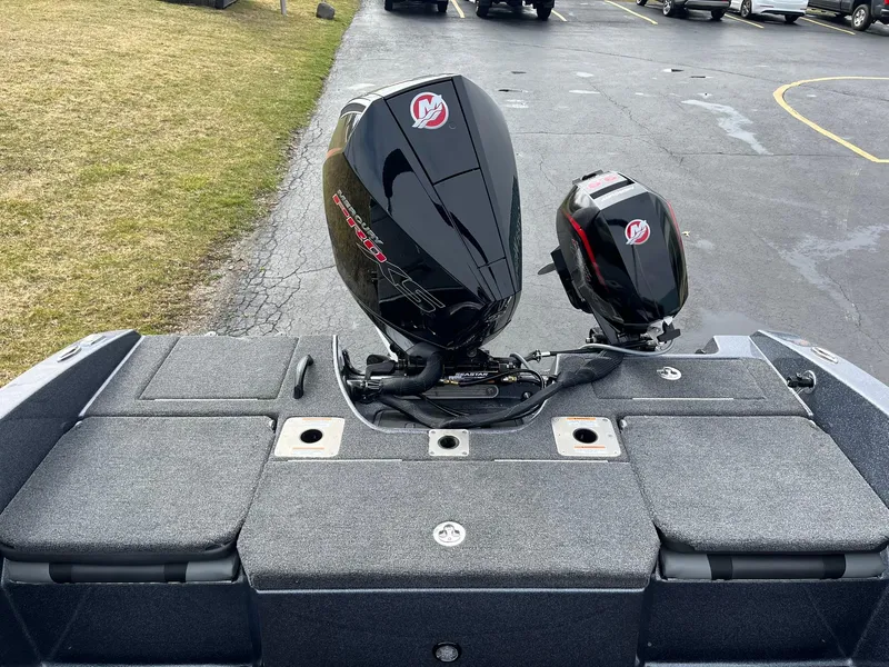 Slide: The Image of 2024 Lund 189 Tyee GL boat with dual outboard motors in a parking lot. - 16