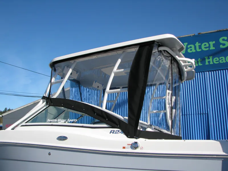 Slide: The Image of 2023 Robalo R247 Dual Console boat with a clear enclosure. - 7