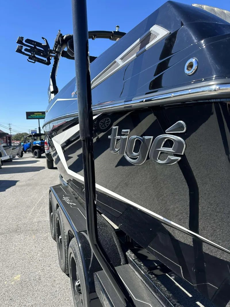 Slide: The Image of 2024 Tigé 24RZX boat, sleek black exterior, parked on a trailer. - 3