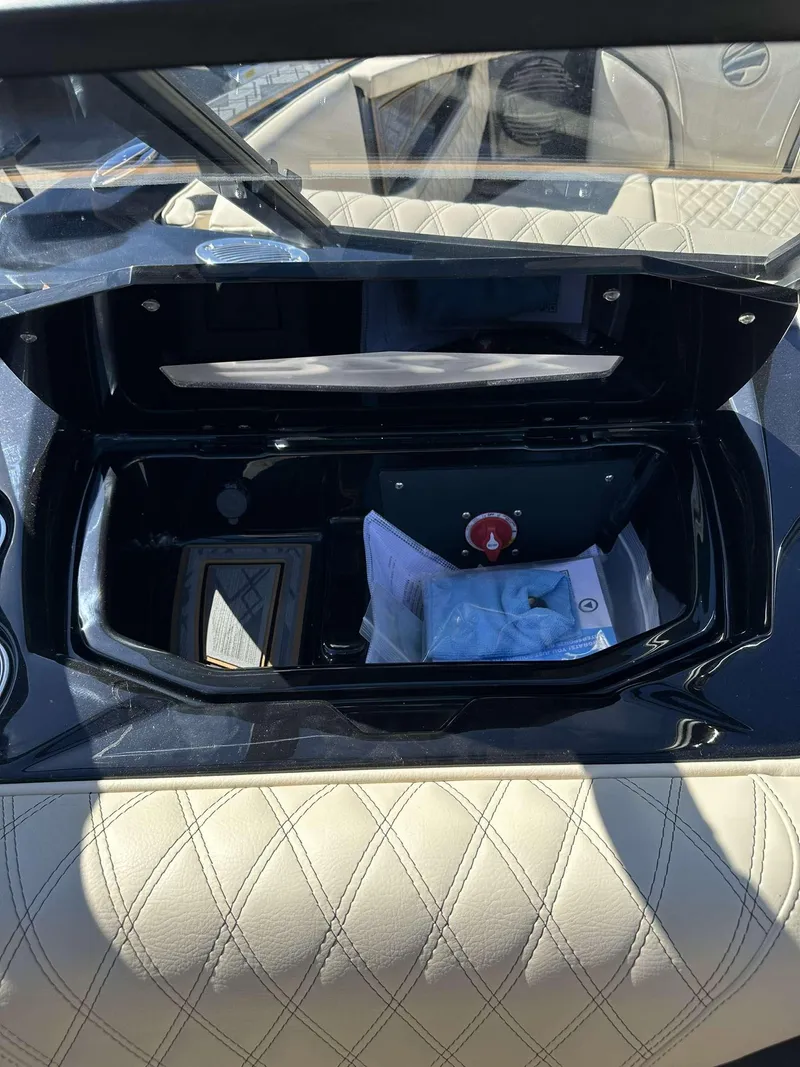 Slide: The Image of 2024 Tigé 24RZX boat dashboard storage compartment with beige diamond-stitched upholstery. - 30