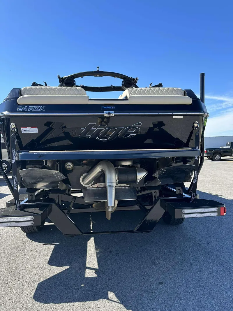 Slide: The Image of 2024 Tigé 24RZX boat rear view with dual exhaust and sleek design. - 7