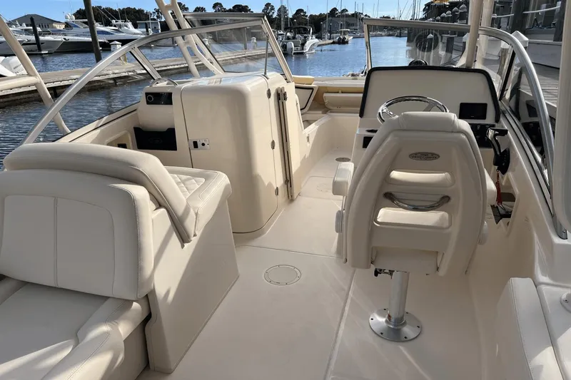 Slide: The Image of 2024 Grady-White Freedom 235 boat interior with white seating and steering console. - 13