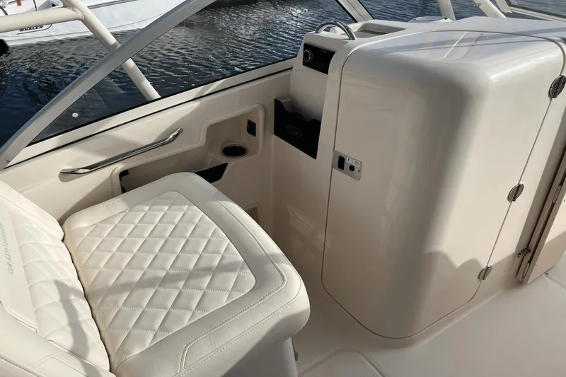 Slide: The Image of Interior of 2024 Grady-White Freedom 235 boat with white quilted seating and storage compartments. - 14